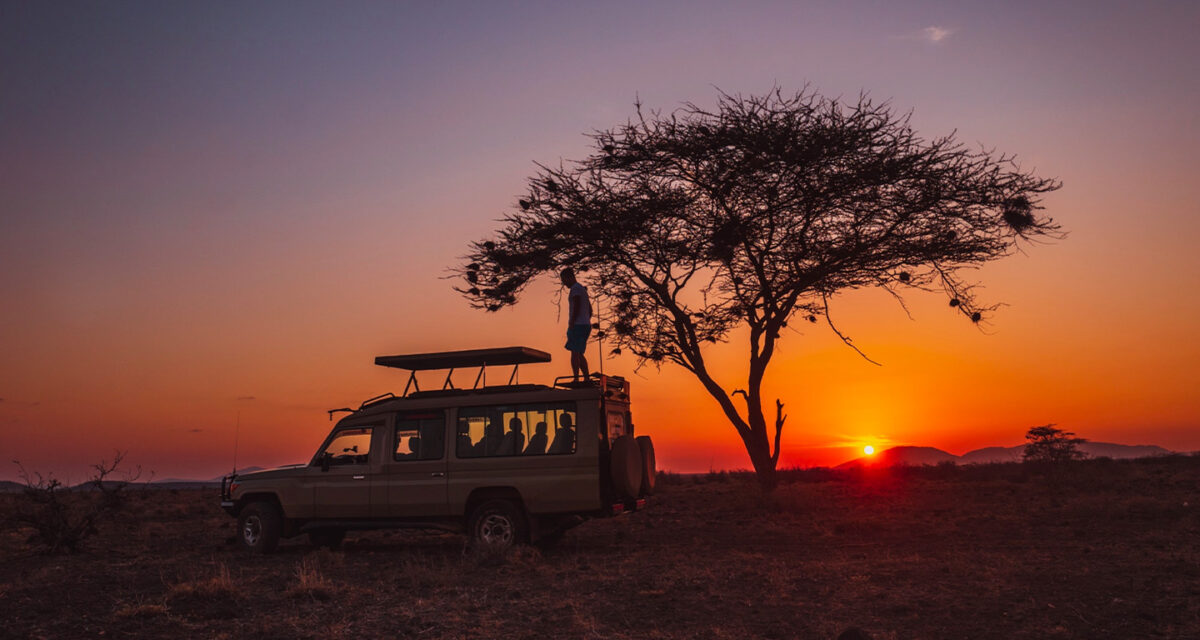 Safari vehicle at sunset on a Murchison Falls game drive