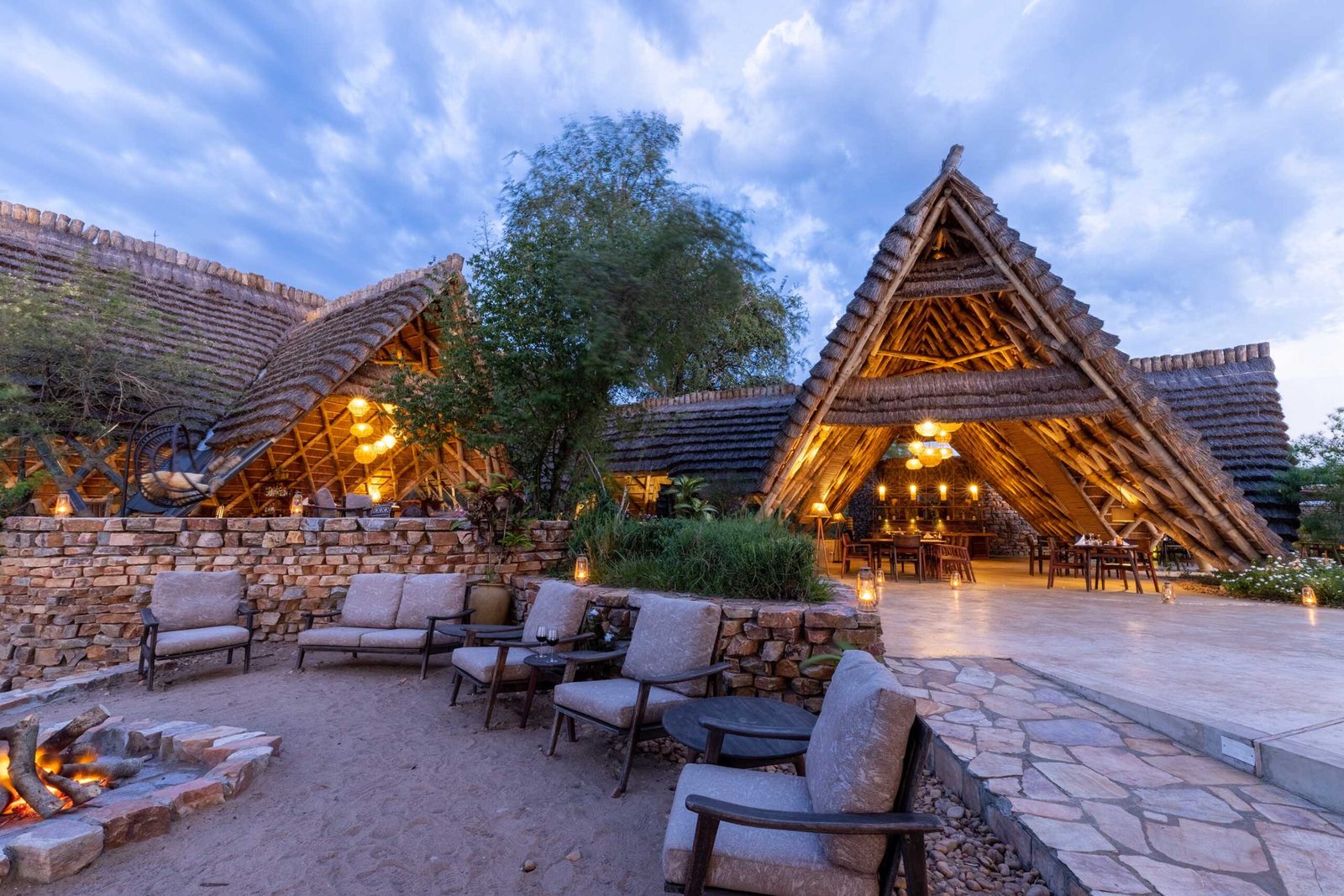 Firepit and lounge at a Murchison Falls river lodge at dusk